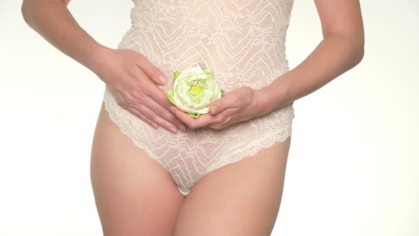 彼女の腹の横に白い蓮の花を保持している妊娠中の女性のクローズ アップ — ストック動画