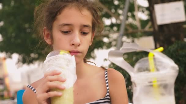 Cansado do calor a menina bebe um cocktail frio através de uma palha, close-up — Vídeo de Stock