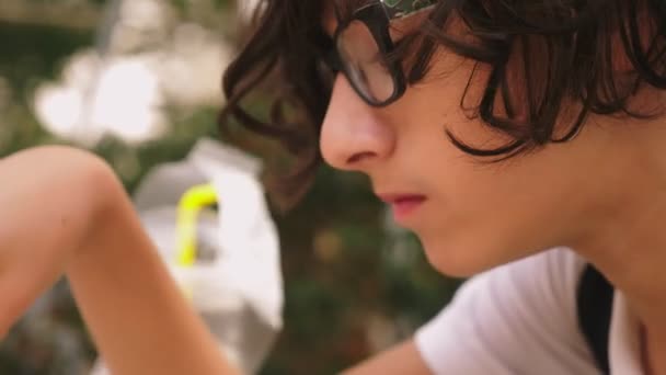 Teen boy eating french fries in an outdoor cafe. close-up — Stock video