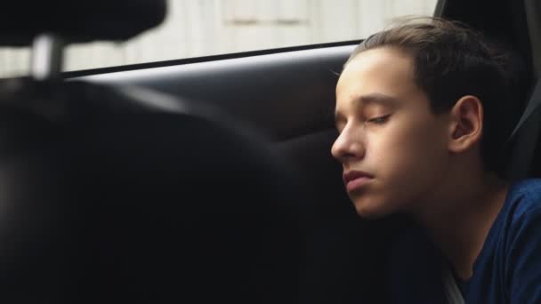 Stäng. Tonårspojke sover i baksätet på bilen — Stockvideo
