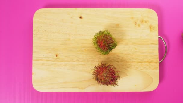 平面図、男性の手の木の板にランブータンが広がった自然健康食品のコンセプト. — ストック動画