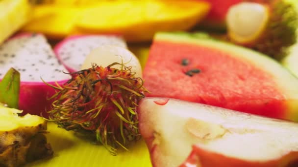 Mixed tropical fruits, closeup. fresh fruit sliced. background. — Stock Video