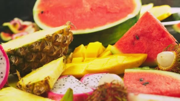 Frutas tropicales mixtas, primer plano. fruta fresca en rodajas. antecedentes . — Vídeo de stock