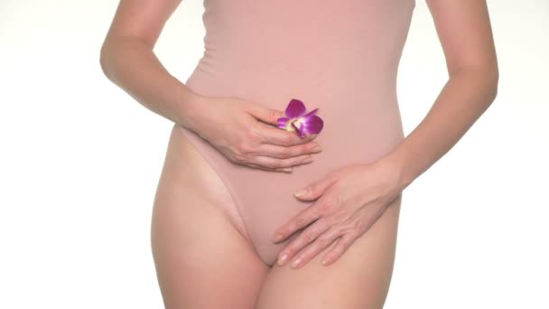 Mujer sosteniendo una flor en el fondo de la ropa interior, el concepto de salud femenina y el cuidado del cuerpo — Vídeos de Stock