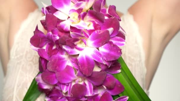 Gros plan. gros plan de poitrine femelle avec un grand bouquet d'orchidées dans leurs mains. concept de santé mammaire féminine — Video