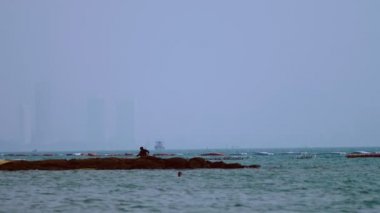 Olta şehir ve gemi arka planı ile bir balıkçı silüeti.