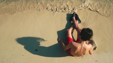 Genç çocuk bina kum kale tropikal plaj