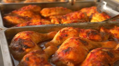 Yakın çekim. Bir tepsi üzerinde domates soslu tavuk budu.