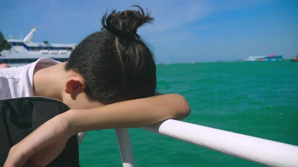 10 代の少年はボート旅行中に乗り物酔いに苦しんで。旅行やクルーズの休暇中にウイルスの病気の恐怖. — ストック写真