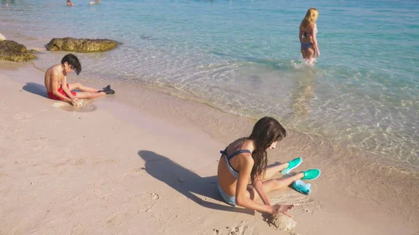 Remaja, kakak beradik membuat istana pasir di pantai tropis — Stok Foto