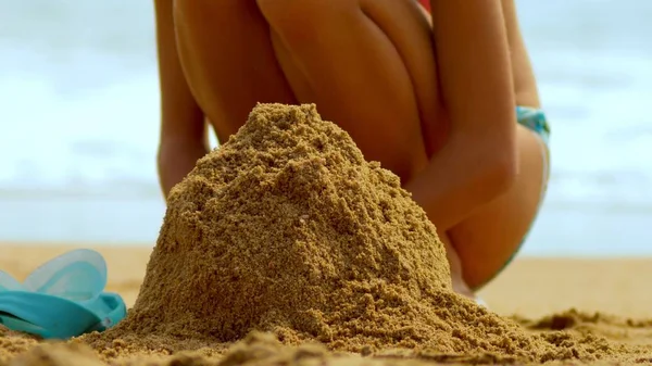 Mädchen baut eine Sandburg am tropischen Strand. Nahaufnahme — Stockfoto