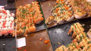 Asya mutfağı, gıda kavramı. kapatın. maşa ile el suşi gece piyasada sokakta seçin..