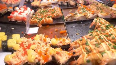 Asya mutfağı, gıda kavramı. kapatın. maşa ile el suşi gece piyasada sokakta seçin.