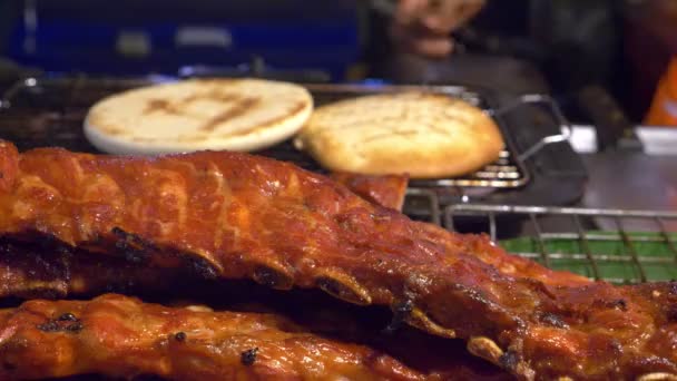 Азиатская кухня, концепция еды. Почти. Барбекю свиные ребрышки на прилавке на ночном рынке на улице . — стоковое видео