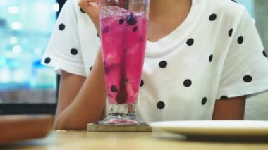 yakın çekim. kız bir saman bir kokteyl içme bir kafede. içecekler, insanlar ve yaşam tarzı