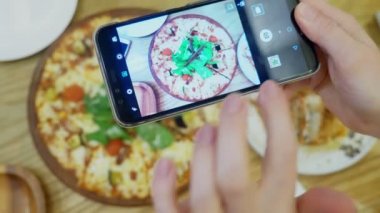 yakın çekim. Eller Smartphone cep telefonu ile restoranda pizza fotoğrafını çekin