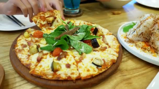 Сім'я в ресторані. руки беруть шматочки піци зі звичайної страви . — стокове відео