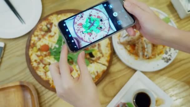 Close-up. Mãos femininas tiram fotos de pizza no smartphone no restaurante . — Vídeo de Stock