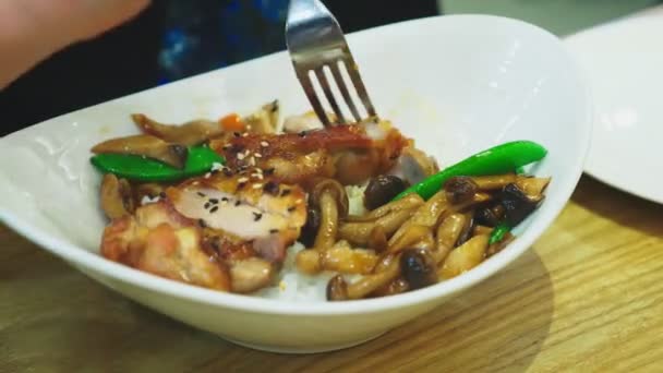 Primer plano. alguien come un plato de cocina asiática en un restaurante . — Vídeo de stock