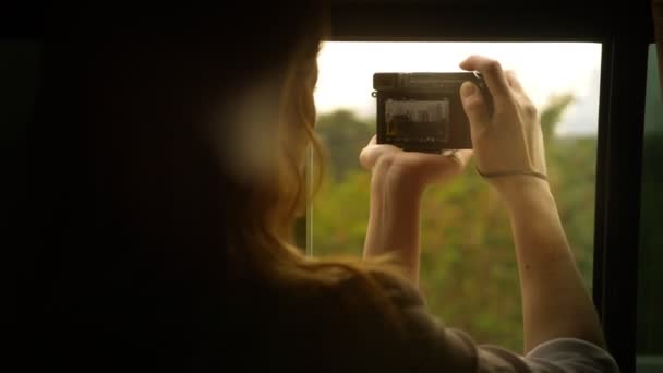 Een vrouw neemt foto's van wolkenkrabbers van een moderne auto. — Stockvideo