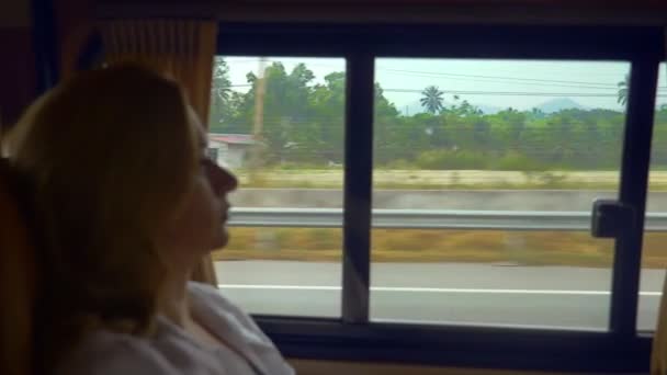 Donna che guarda fuori dal finestrino, appoggiata sull'accogliente sedile posteriore di un'auto moderna . — Video Stock