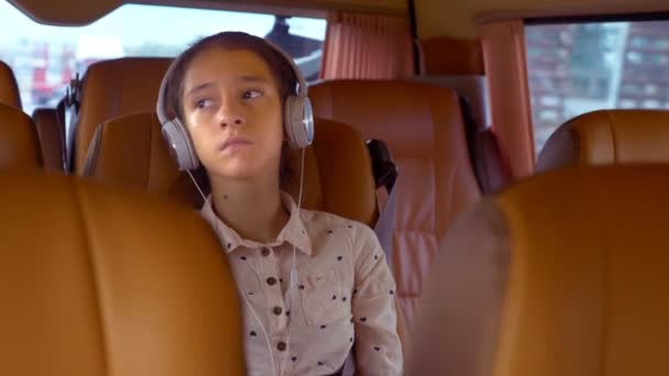 Het concept van de zomervakantie, reizen. tiener meisje rijdt in een minibus met koptelefoon — Stockvideo