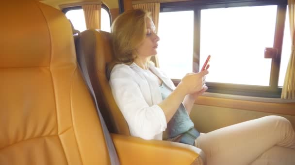 Женщина пользуется телефоном, сидя на пассажирском сидении минивэна . — стоковое видео