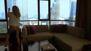 panoramik bir pencere içinde gökdelenler arka bavula kadınla