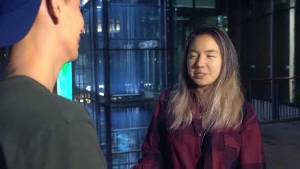 Jovem lindo casal asiático, cara e menina estão falando uns com os outros, de pé na rua da cidade — Vídeo de Stock