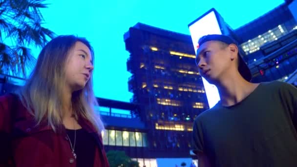 Genç güzel Asyalı Çift, adam ve kız birbirleri ile şehir sokakta duran konuşuyorsun — Stok video