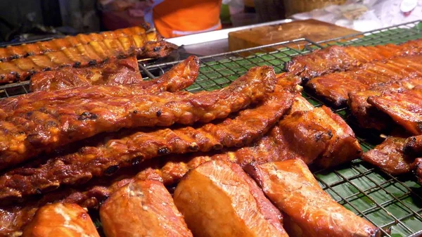 Aziatische keuken, voedsel concept. sluit. BBQ-varkensribbetjes op de teller op de night market op straat. — Stockfoto