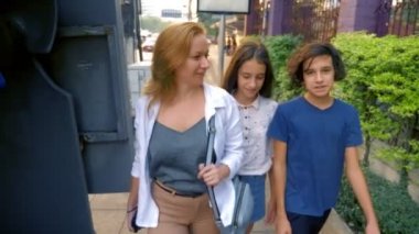 kadın olan çocuklar, oğlu ve kızı gençler bir kamera ile büyük modern bir şehir sokaklarında yürüyor