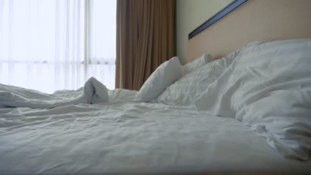 Hravý muž skákání na posteli proti oknu. — Stock video