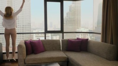 panoramik bir pencere içinde gökdelenler arka bavula kadınla
