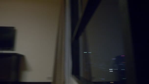 Счастливая семья, женщина, мужчина и двое детей с чемоданом на фоне небоскребов в панорамном окне вечером — стоковое видео