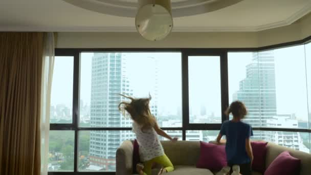 Familia feliz, mujer, hombre y dos niños con una maleta en el fondo de rascacielos en una ventana panorámica — Vídeos de Stock