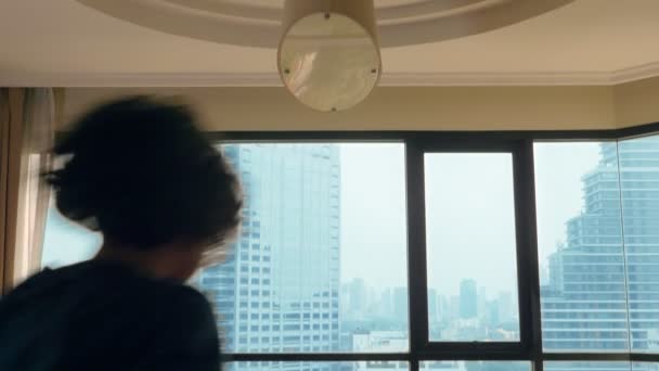 幸福的家庭 男人和两个孩子拿着一个行李箱 在全景窗口的摩天大楼背景上 — 图库视频影像