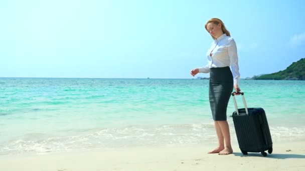 Γυναίκα επιχειρηματία και τις επιχειρήσεις με μια βαλίτσα περπατώντας κατά μήκος του παραλία με λευκή άμμο στο νησί — Αρχείο Βίντεο