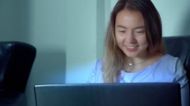 şirin Asyalı kadın geceleri dizüstü bilgisayar kullanmak