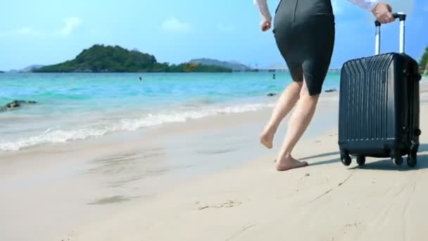 Деловая женщина в офисной одежде бежит босиком к морю вдоль белого песчаного пляжа. фрилансер, концепция долгожданного отпуска — стоковое видео
