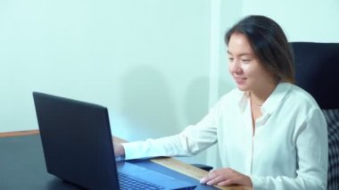 şirin Asyalı kız masa ofis dizüstü bilgisayar kullanmak