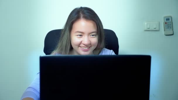 かわいいアジアの女の子が事務所のテーブルでラップトップを使用します。 — ストック動画