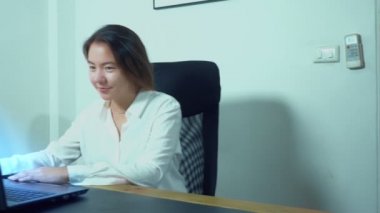şirin Asyalı kız masa ofis dizüstü bilgisayar kullanmak