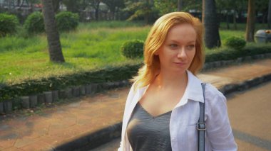 Şehir merkezinde acele altın saçlı çekici genç kadın.