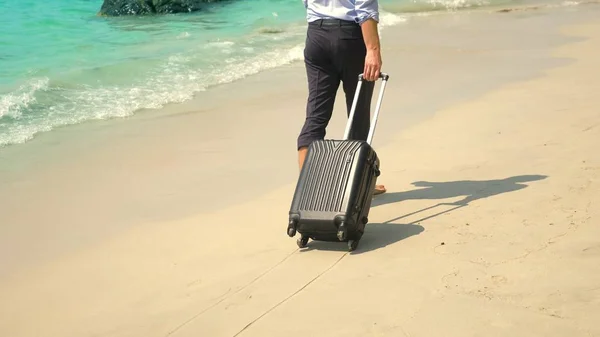 Pengusaha dengan koper berjalan di pantai berpasir putih. konsep freelancing, liburan — Stok Foto