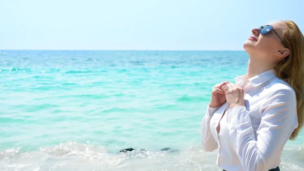 Mujer de negocios en la playa. disfruta de la vista al mar. se desabrochó la camisa y respira el aire del mar — Foto de Stock