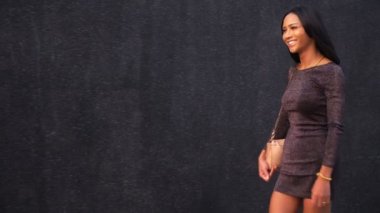 Güzel bir ince Asyalı Kız Ladyboy siyah duvarın dışında arka plan üzerinde yürüyor. Tay transseksüel model.