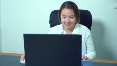 şirin Asyalı kız masa ofis dizüstü bilgisayar kullanmak