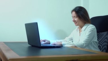 şirin Asyalı kız masa ofis dizüstü bilgisayar kullanmak