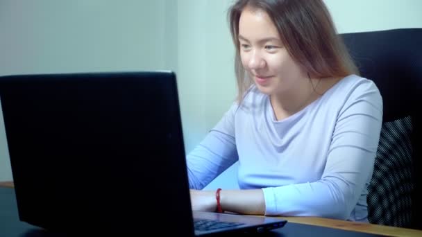 Ασιατικό χαριτωμένο κορίτσι χρησιμοποιούν φορητό υπολογιστή στο τραπέζι στο γραφείο — Αρχείο Βίντεο